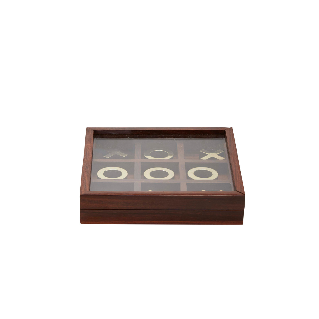 En glaslåst Tre i Rad Spel i Träask-låda av Margit Brandt avslöjar tic-tac-tå-bitar arrangerade i ett rutnät inuti.